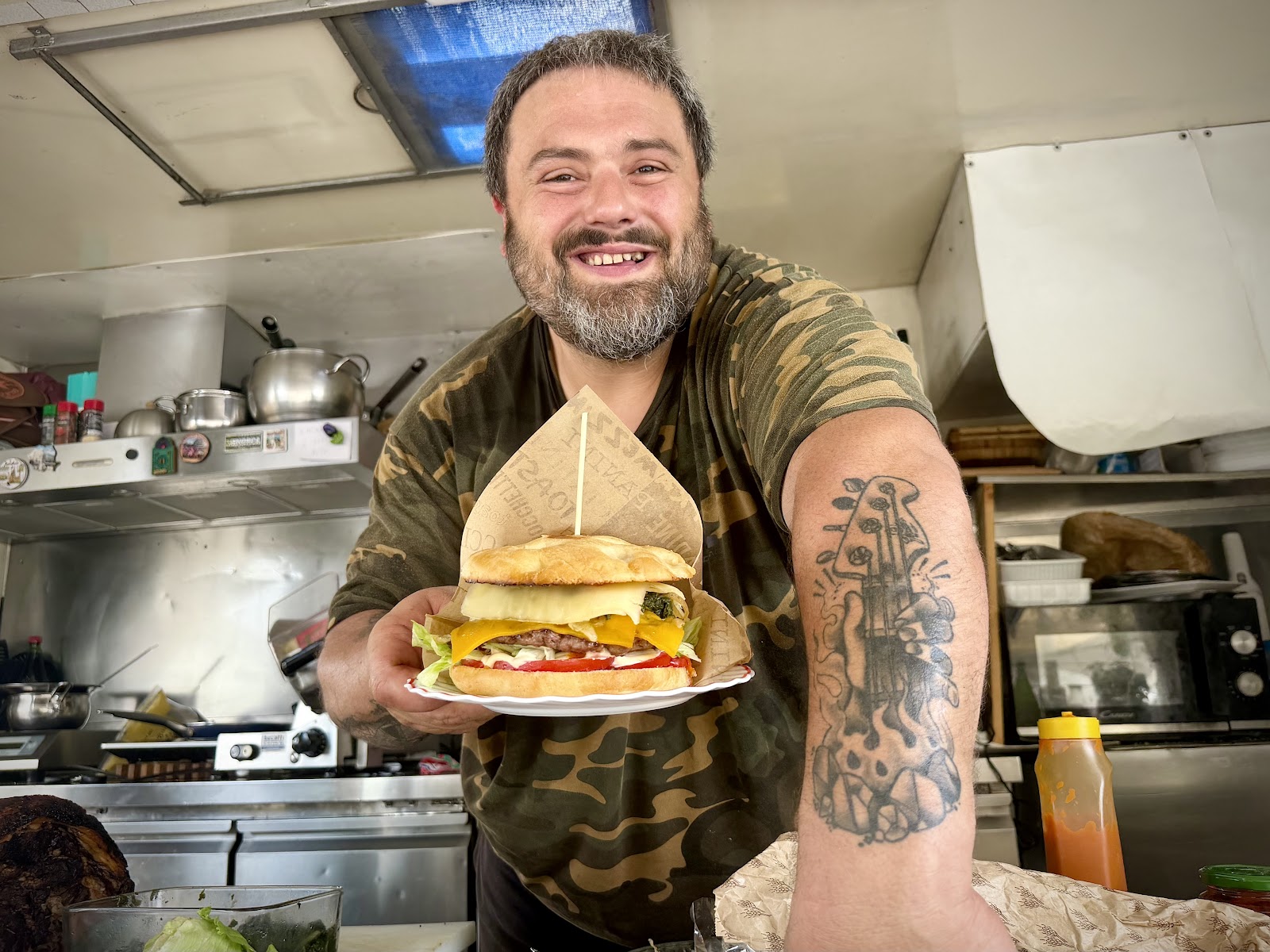 Milkone sorridente che serve un hamburger dal suo chiosco
